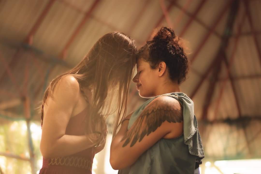Two women touching foreheads in quiet presence